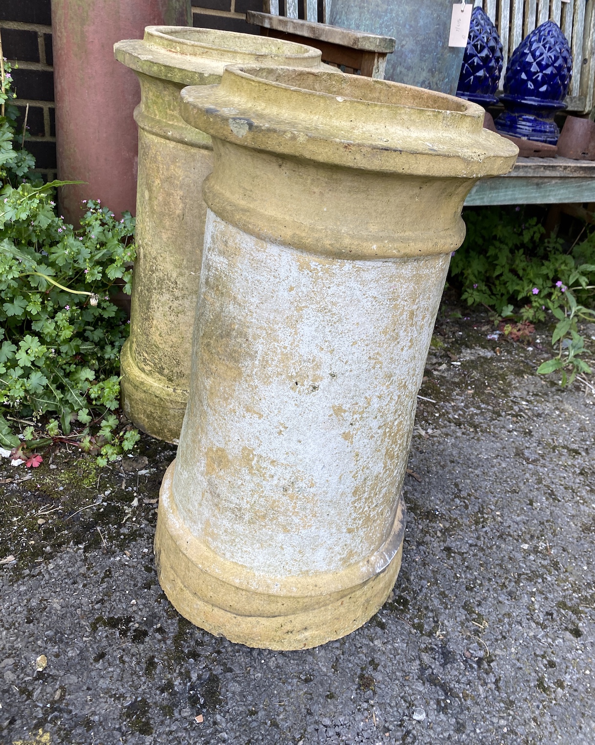 Three earthenware chimney pots, two as garden planters and one as a plinth with slate top, largest 120cm